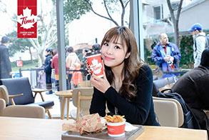 Tim Hortons® Shanghai guest smiling and holding a coffee cup
